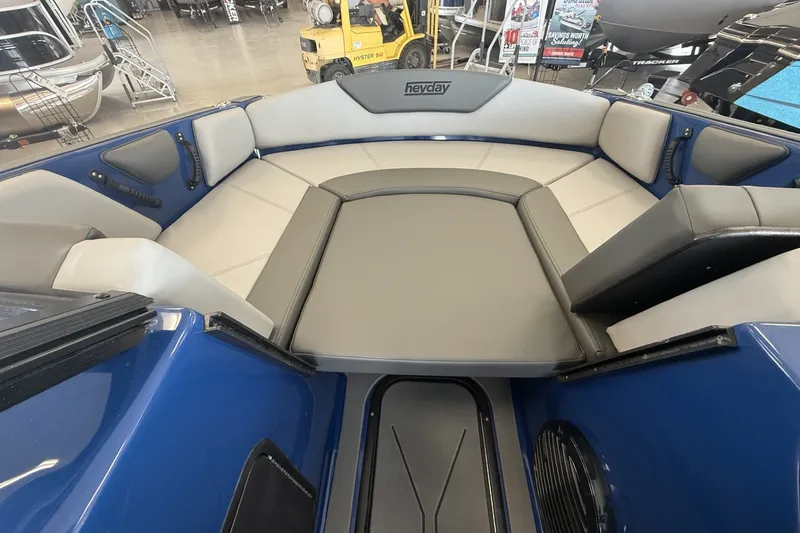 Slide: The Image of 2026 Heyday WT-2DC boat interior with gray seating and blue accents in showroom. - 12
