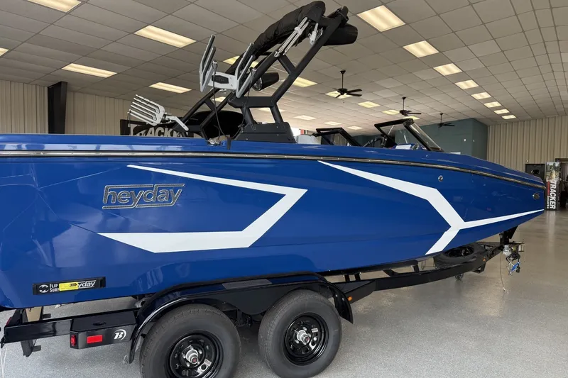 Slide: The Image of 2026 Heyday WT-2DC boat in showroom, blue with white accents, on trailer. - 1