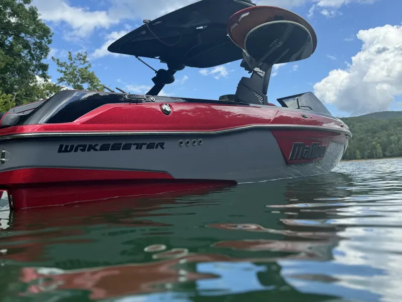 The Image of A red 2022 Malibu Wakesetter 23 LSV boat floats on a calm lake. - 0