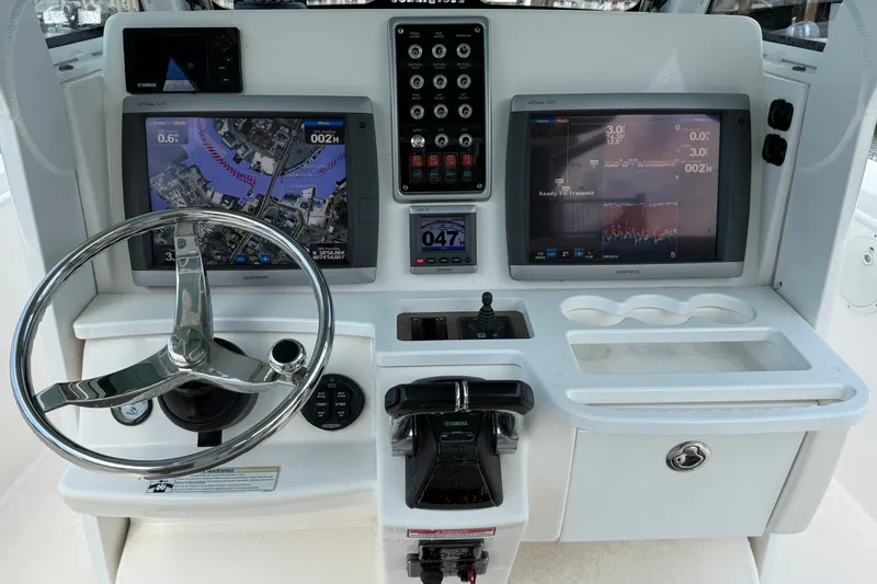 Slide: The Image of Center console of 2012 Everglades 325 boat with navigation screens and steering wheel. - 10