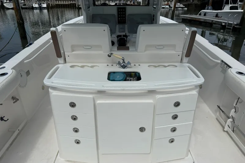 Slide: The Image of 2012 Everglades 325 Center Console boat interior with storage and sink, docked at marina. - 24