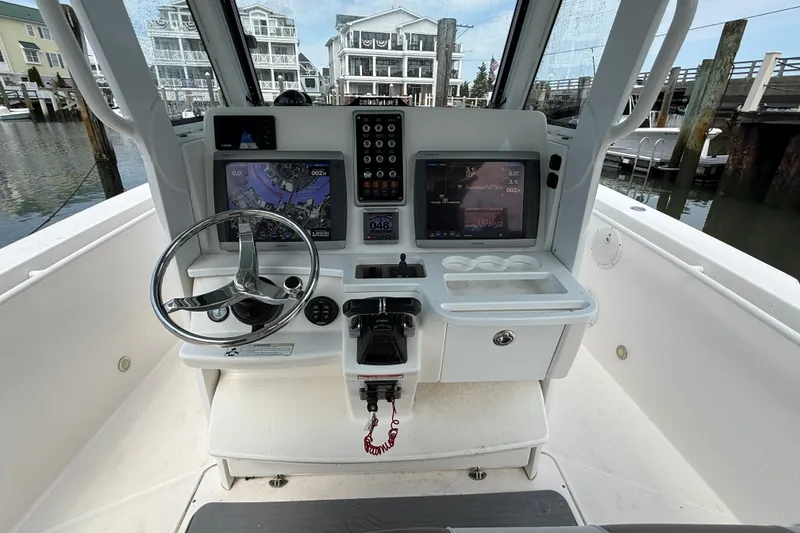 Slide: The Image of 2012 Everglades 325 Center Console boat dashboard with navigation screens and steering wheel. - 9