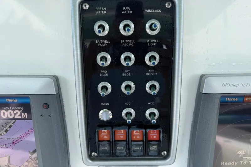 Slide: The Image of Control panel of a 2012 Everglades 325 Center Console boat with various switches and GPS displays. - 12