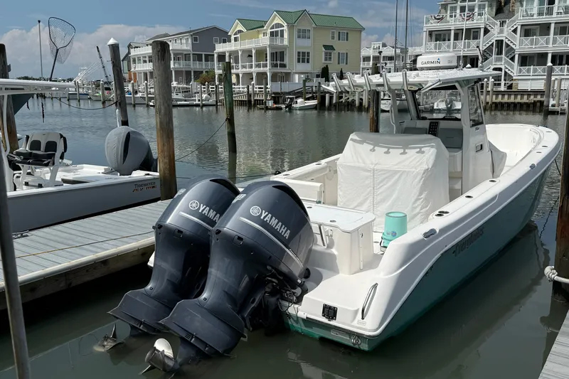 Slide: The Image of 2012 Everglades 325 Center Console boat docked with twin Yamaha engines. - 2