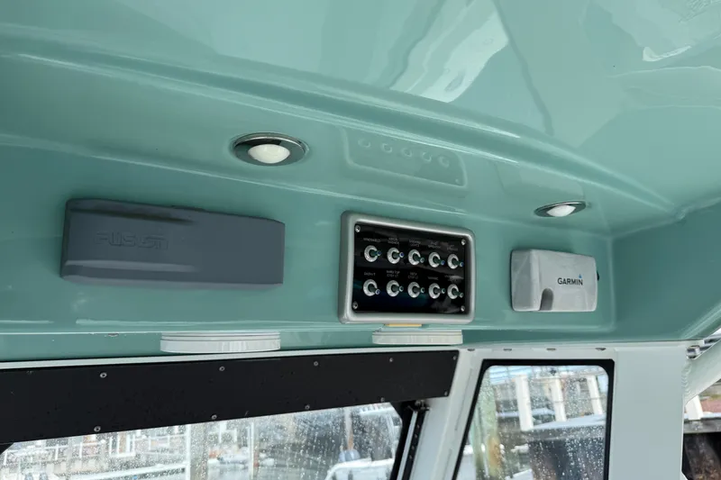 Slide: The Image of Interior view of a 2012 Everglades 325 Center Console boat dashboard with Garmin and Fusion equipment. - 14