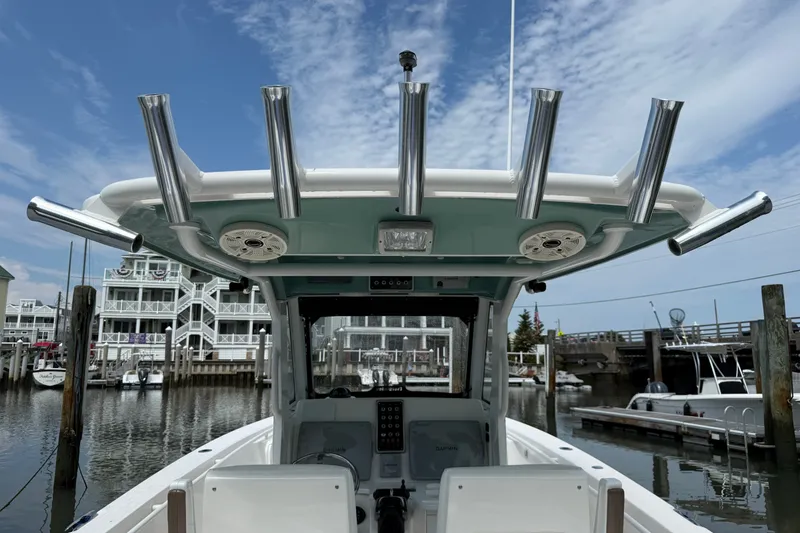 Slide: The Image of 2012 Everglades 325 Center Console boat docked at marina, featuring rod holders and speakers. - 8