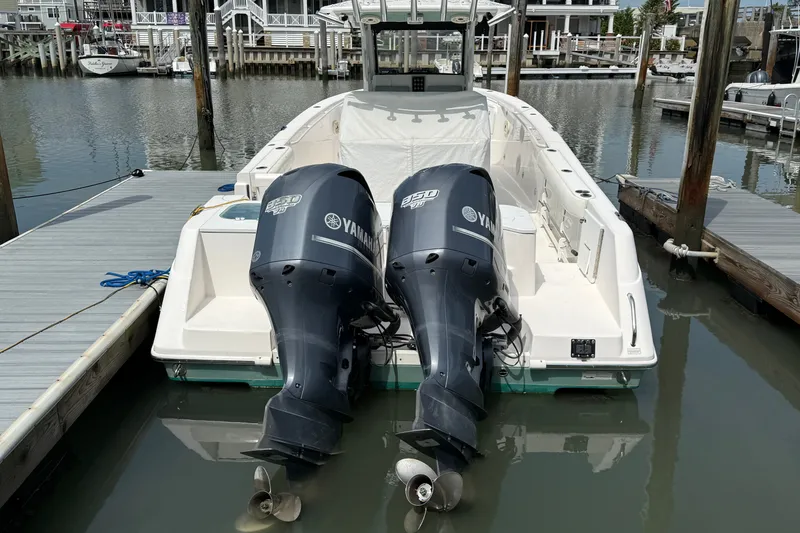 Slide: The Image of 2012 Everglades 325 Center Console boat with twin Yamaha engines docked in a marina. - 7