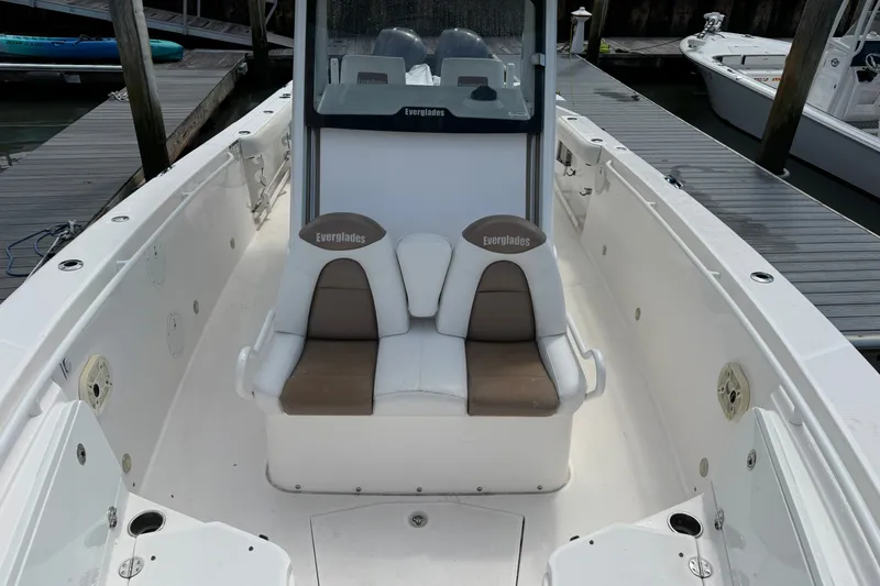 Slide: The Image of 2012 Everglades 325 Center Console boat interior with cushioned seating at dock. - 21