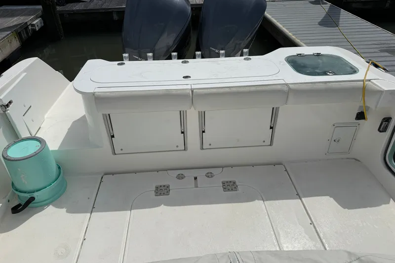 Slide: The Image of 2012 Everglades 325 Center Console boat interior with storage compartments and twin engines. - 22