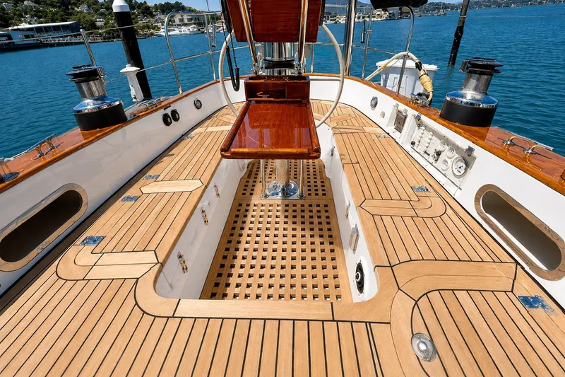 Slide: The Image of Luxurious 1989 Mason 54 yacht deck with polished wood finish and ocean backdrop. - 13