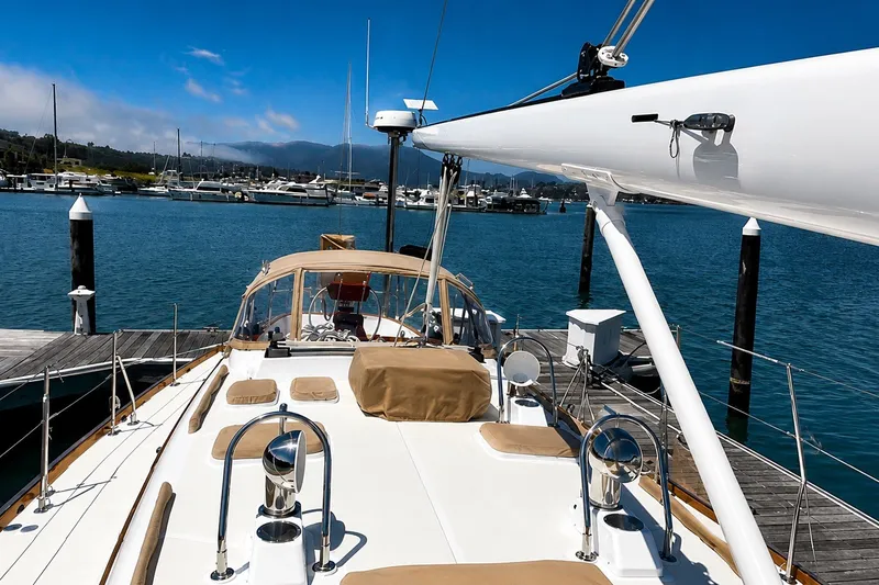 Slide: The Image of Sailboat docked at marina, Mason 54 model, 1989, with clear blue sky and water. - 11