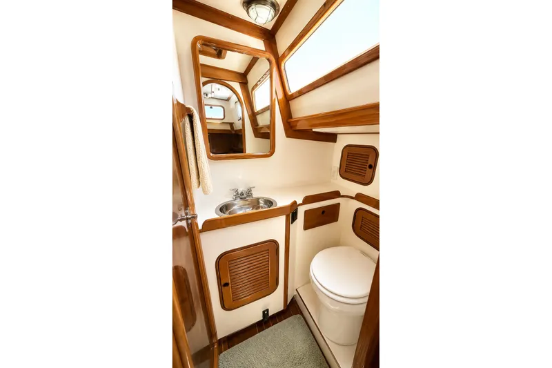 Slide: The Image of 1989 Mason 54 yacht bathroom with wooden accents, mirror, sink, and toilet. - 39