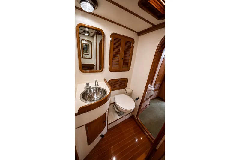 Slide: The Image of 1989 Mason 54 yacht bathroom with wooden accents, sink, and toilet. - 37