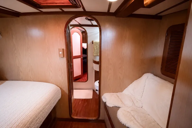 Slide: The Image of Cozy cabin interior of 1989 Mason 54 yacht with wood paneling and plush seating. - 36