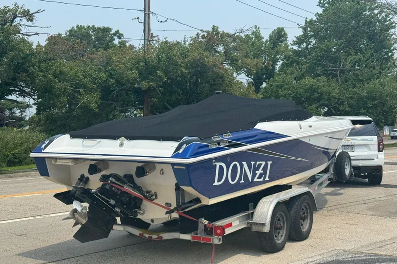 Slide: The Image of 2009 Donzi 27 ZR boat on trailer, covered, parked on roadside. - 3