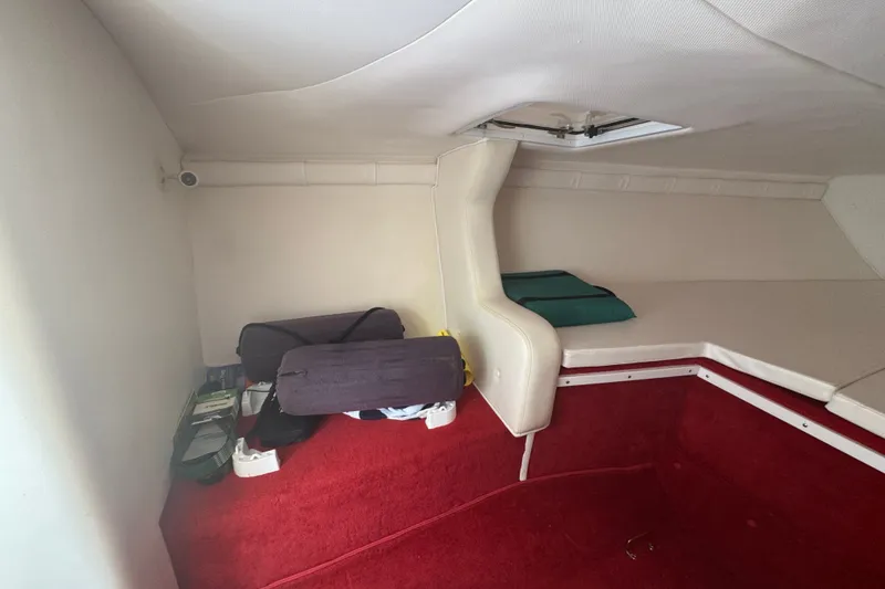 Slide: The Image of Interior cabin of 2009 Donzi 27 ZR boat with red carpet and storage bags. - 30