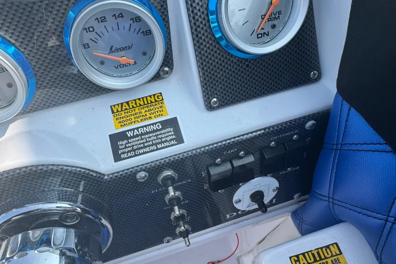Slide: The Image of Dashboard of a 2009 Donzi 27 ZR boat with gauges and warning labels. - 24