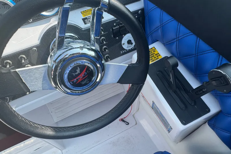 Slide: The Image of 2009 Donzi 27 ZR boat cockpit with steering wheel and blue quilted seat. - 23