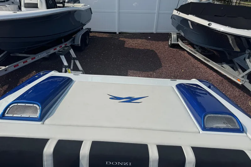Slide: The Image of 2009 Donzi 27 ZR boat rear view with blue accents, parked on a trailer. - 15