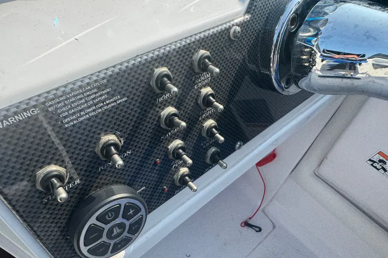 Slide: The Image of 2009 Donzi 27 ZR boat dashboard with switches and controls, featuring carbon fiber panel. - 22