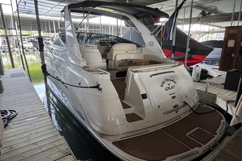 The Image of 2005 Chaparral Signature 350 yacht docked in a marina, featuring a sleek white design. - 2
