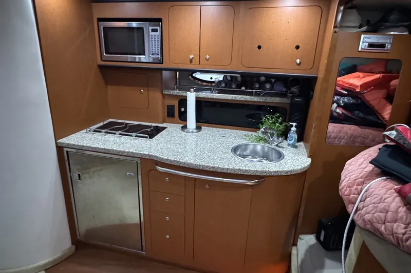 Slide: The Image of 2005 Chaparral Signature 350 yacht interior kitchen with microwave, stove, and sink. - 13
