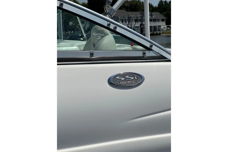 Slide: The Image of 2003 CHAPPARRAL 260 SSI boat emblem and interior detail near water. - 6