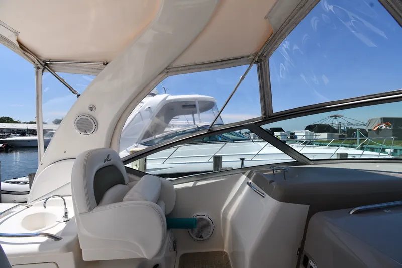 Slide: The Image of 2007 Sea Ray 340 Sundancer cockpit with helm, marina view, and clear blue sky. - 16