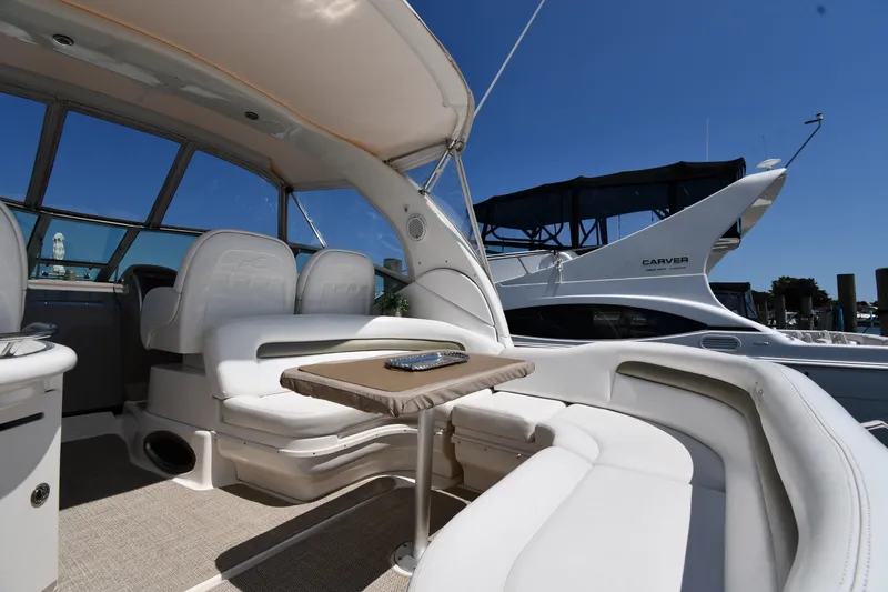 Slide: The Image of Luxurious 2007 Sea Ray 340 Sundancer yacht interior with seating and table, docked under clear skies. - 17