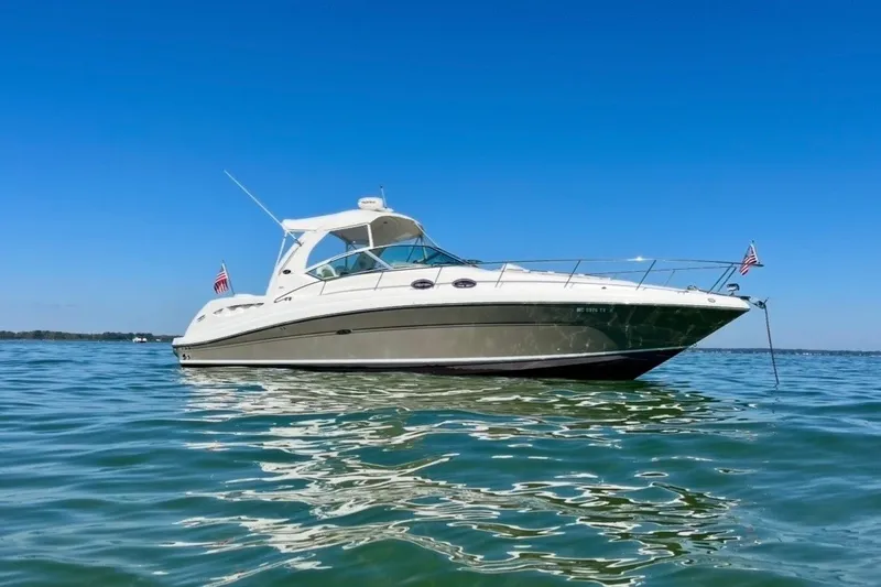 The Image of 2007 Sea Ray 340 Sundancer yacht anchored on calm water under clear blue sky. - 0