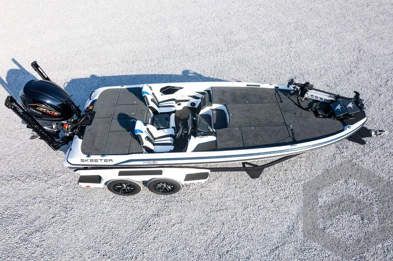 Slide: The Image of 2027 Skeeter FXE21 Limited boat on trailer, top view, parked on gravel surface. - 36
