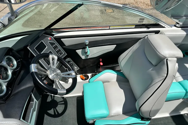 Slide: The Image of Interior of a 2018 MasterCraft XT23 boat, featuring a sleek steering wheel and modern dashboard. - 27