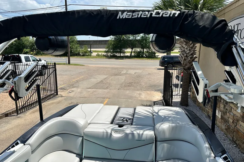 Slide: The Image of 2018 MasterCraft XT23 boat interior with cushioned seating and wakeboard tower. - 24