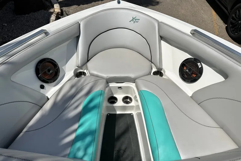 Slide: The Image of 2018 MasterCraft XT23 boat interior with gray and teal seating, featuring built-in speakers. - 30