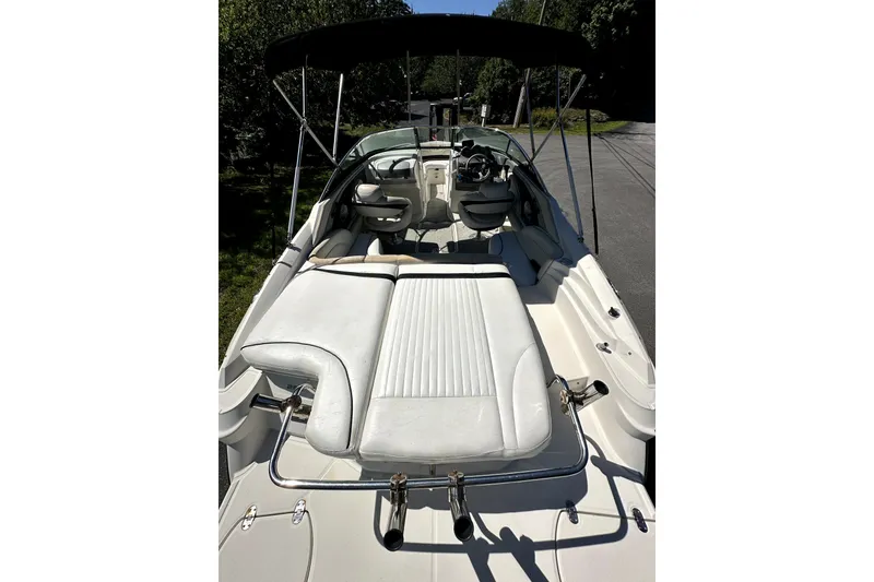 Slide: The Image of 2007 Monterey 234FSX boat with white seating and black canopy, parked outdoors. - 6