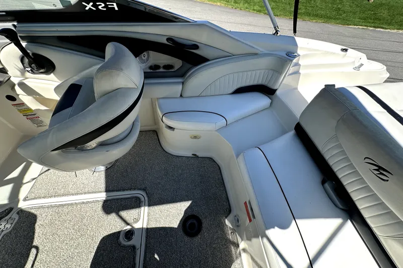Slide: The Image of Interior of a 2007 Monterey 234FSX boat with white seating and steering wheel. - 12