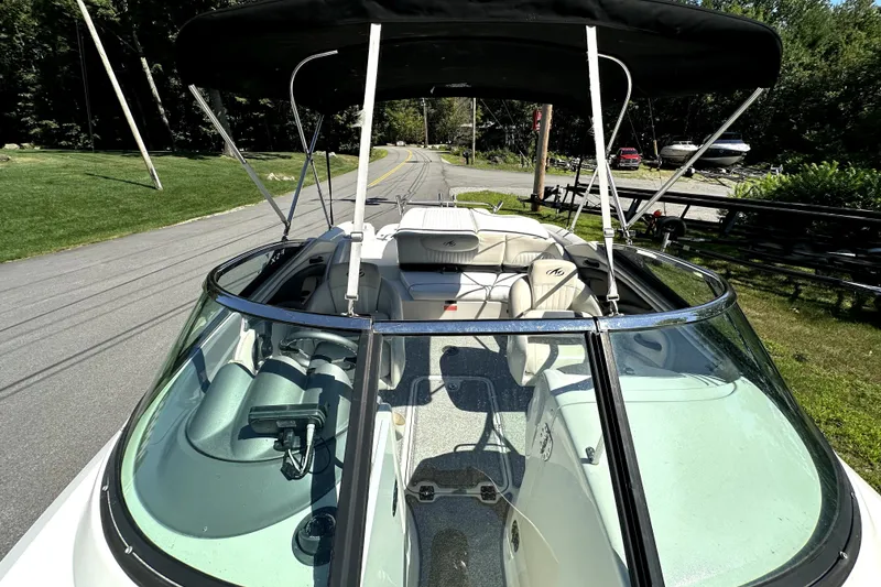 Slide: The Image of 2007 Monterey 234FSX boat with canopy, parked on a road near greenery. - 11