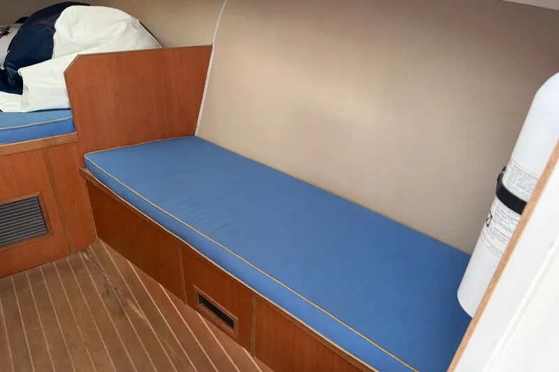 Slide: The Image of Interior of 2007 Outerbanks Express boat with blue cushioned seating and wooden paneling. - 28