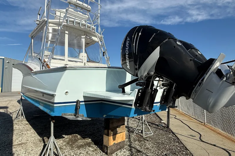 Slide: The Image of 2007 Outerbanks Express boat with Mercury outboard motor on dry dock under clear sky. - 32