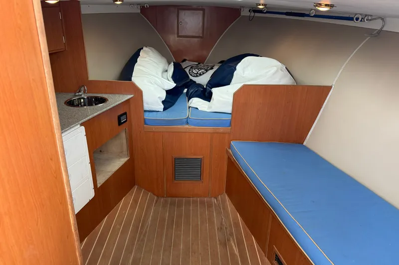 Slide: The Image of Interior of a 2007 Outerbanks Express boat with wooden cabinetry and blue cushions. - 26