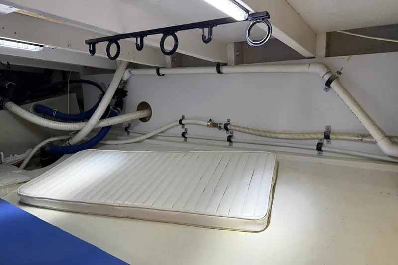 Slide: The Image of 2007 Outerbanks Express boat interior with mattress and visible piping. - 31