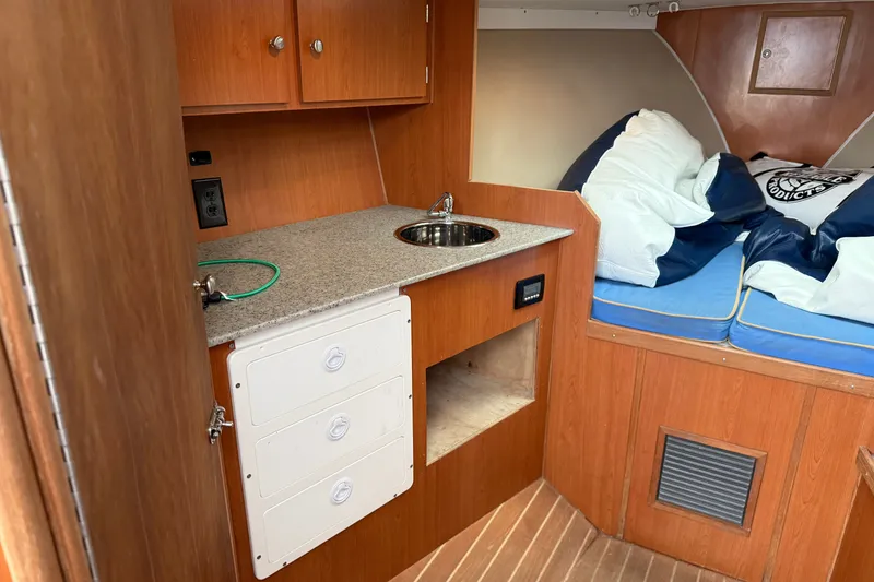Slide: The Image of Compact cabin interior of 2007 Outerbanks Express boat with kitchenette and sleeping area. - 27
