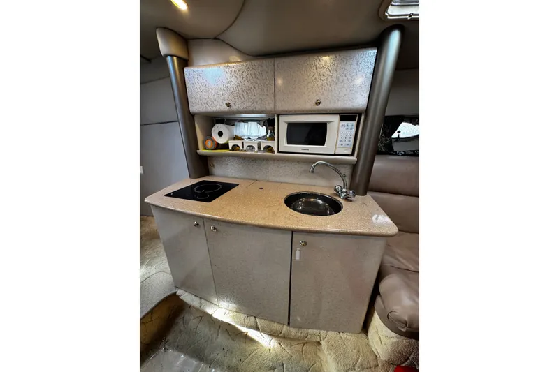 Slide: The Image of Compact kitchen area in a 2004 Formula 370 Super Sport boat with sink and microwave. - 18
