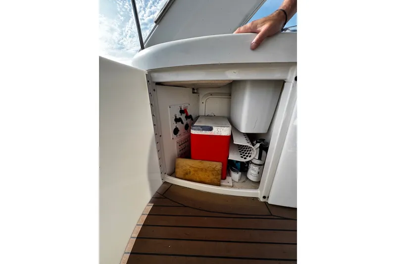 Slide: The Image of Open storage compartment on 2004 Formula 370 Super Sport boat, showing equipment and supplies. - 25