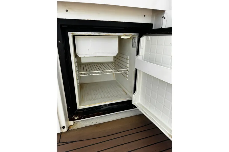 Slide: The Image of Open mini fridge on 2004 Formula 370 Super Sport boat, showing empty interior shelves. - 24