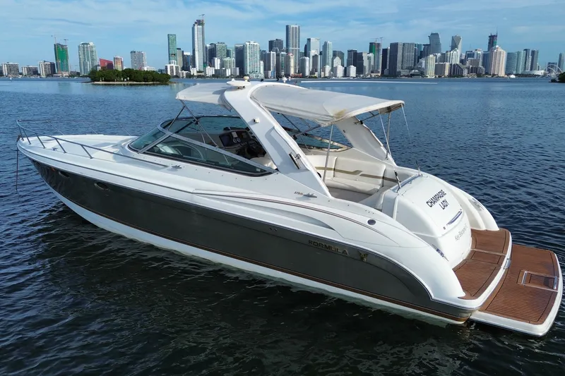 The Image of A white and gray motor yacht is docked with a city skyline in the background. - 0