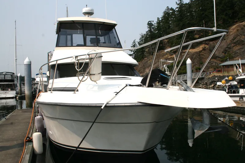 Slide: The Image of 1989 Silverton 34 Convertible yacht docked at marina, front view. - 1