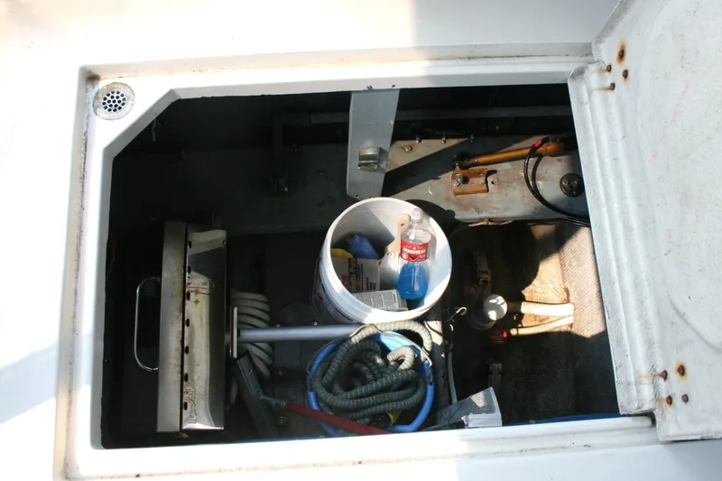 Slide: The Image of Open hatch of 1989 Silverton 34 Convertible boat showing storage compartment with various items. - 31