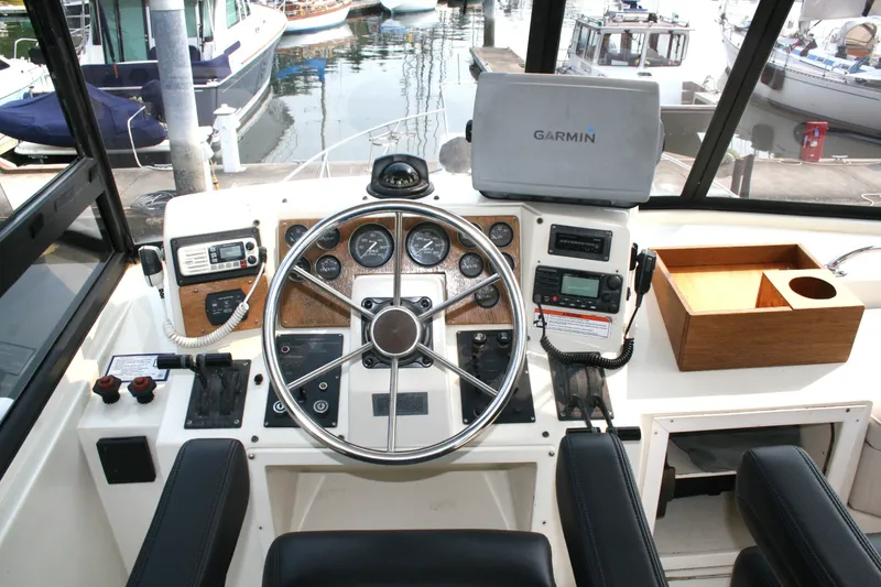 Slide: The Image of Cockpit of 1989 Silverton 34 Convertible boat with steering wheel and navigation equipment. - 4