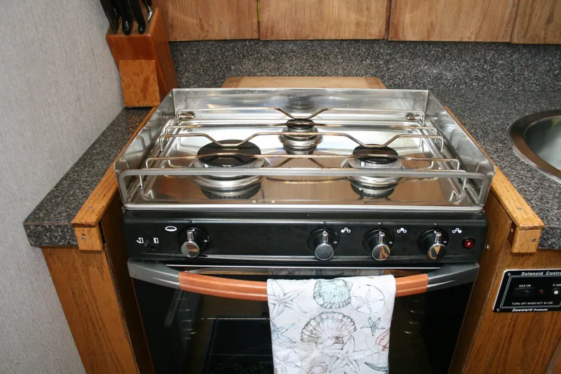 Slide: The Image of 1989 Silverton 34 Convertible kitchen with a three-burner stove and wooden cabinetry. - 18